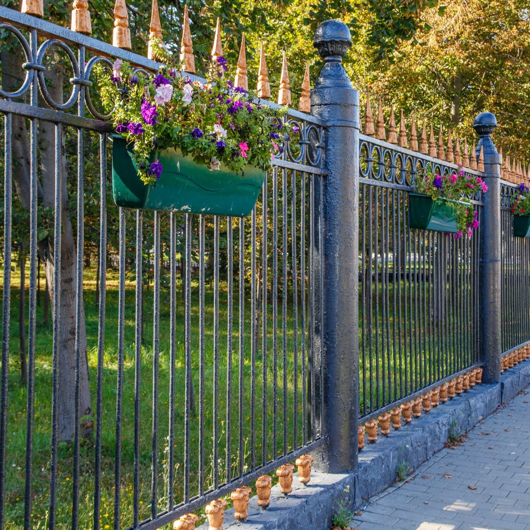 ornamental-forged-ironfence-with-colorful-flower-planters-urban-park-1080x1080