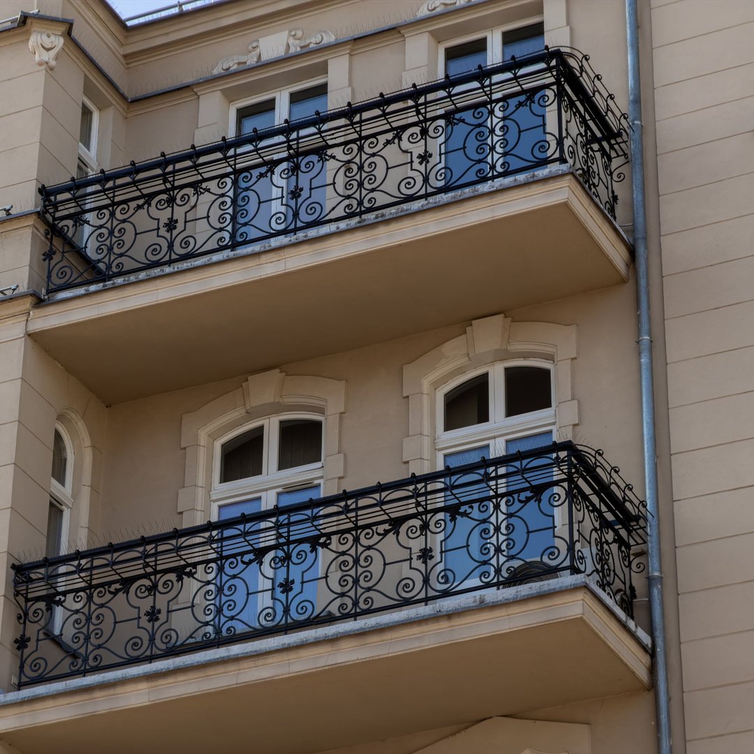ornate-iron-balcony-railing-beige-residential-building-facade-highlighting-classical-archi-1080x1080